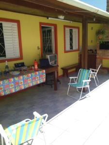 a patio with two chairs and a table and a desk at Pousada Cabral in São Gabriel