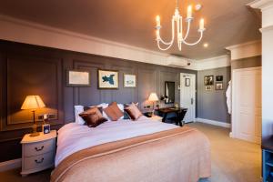 um quarto com uma cama grande e um lustre em The Brewers Inn em Londres