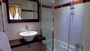 uma casa de banho com um lavatório e um chuveiro em Hôtel L'Iroko The Originals City em Aix-les-Bains