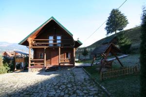 ein kleines Holzhaus mit einem steinernen Gehweg davor in der Unterkunft ЕКО-котедж in Werchowyna
