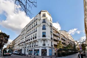 a tall white building on a city street at Hôtel de ville in Levallois-Perret