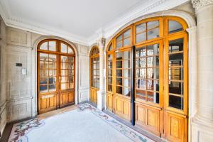 an empty room with wooden doors and a rug at Hôtel de ville in Levallois-Perret