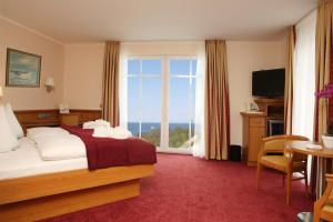 ein Hotelzimmer mit einem Bett und einem großen Fenster in der Unterkunft AKZENT Waldhotel Spa Rügen in Göhren
