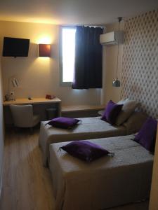 um quarto de hotel com duas camas e uma secretária em La Quietat em Toulouse