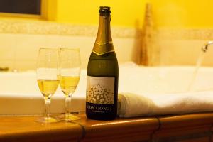 a bottle of champagne and two wine glasses on a counter at Marwood Villas in Halls Gap