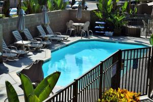 a large swimming pool with chairs and a fence at Multi Resorts at Aquamarine Villas in Oceanside