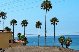 a view of the ocean from a house with palm trees at Multi Resorts at Aquamarine Villas in Oceanside