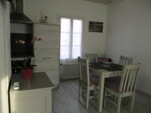 uma cozinha e sala de jantar com mesa e cadeiras em STUDIO 2 PERS PROCHE PLAGE ET COMMERCES em Sainte-Marie-de-Ré