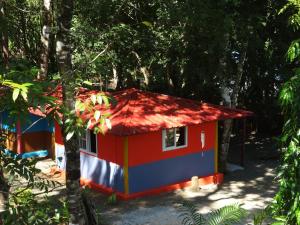 una casa roja blanca y azul en el bosque en Cebaco Sunrise Lodge en Isla Cebaco 