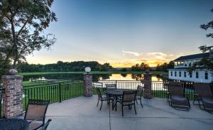 a patio with a table and chairs and a view of a lake at AmericInn by Wyndham Vidalia in Vidalia