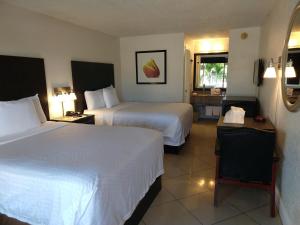 a hotel room with two beds and a window at Red Carpet Inn Airport Fort Lauderdale in Fort Lauderdale +22 photos