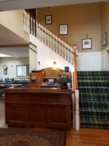 a living room with a staircase and a wooden desk at Lady MacDonald Country Inn in Canmore