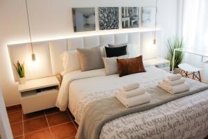 a bedroom with a large bed with towels on it at Apartment Design Marbella in Estepona
