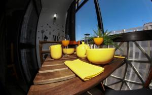a wooden table with yellow dishes on a balcony at Place in theSun Residence in Armação de Pêra