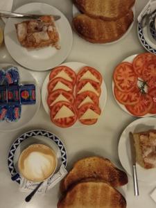 una mesa llena de diferentes tipos de pan y tomates en Hotel Casa de Caldelas, en Castro Caldelas