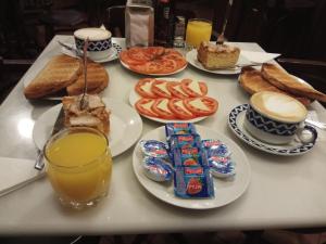a table topped with plates of food and orange juice at Hotel Casa de Caldelas in Castro Caldelas