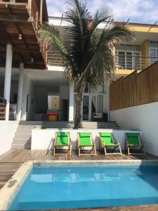 a pool with chairs and a palm tree next to a house at Casa de playa Vichayito Relax in Vichayito