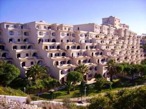 a large building with palm trees in front of it at ColinaSol Vale Centeanes Appartement vue mer in Carvoeiro