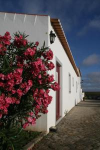 un edificio con flores rosas a su lado en Monte Da Morena Agro-Turismo, en Serpa