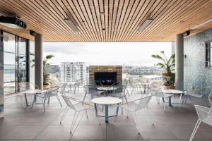 d'un balcon avec des tables et des chaises et une cheminée. dans l'établissement Citadines Connect Sydney Airport, à Sydney