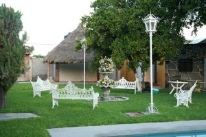 a group of white benches in a yard with a street light at Finca de los Angeles in Chiconcuac