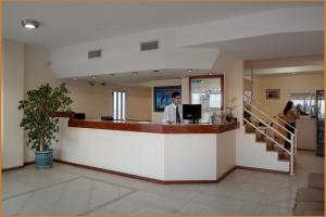 a man standing at a bar in a lobby at Hotel Mirador Del Golfo in Las Grutas