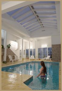 Kobieta siedzi w basenie. w obiekcie Hotel Mirador Del Golfo w mieście Las Grutas