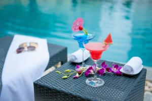 Tuyên Quang的住宿－圖岩況芒坦格蘭德酒店，坐在泳池旁的桌子上,喝上两杯鸡尾酒