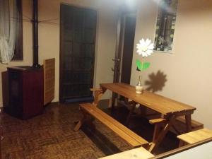 Pokój z drewnianym stołem z kwiatem na ścianie w obiekcie Az.Agr.Cascina Moretta w mieście Momo