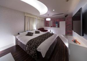 a hotel room with a large bed and a flat screen tv at hotel SWEET SEASON in Hashima