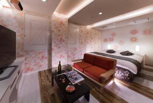 a bedroom with a bed and a couch and a tv at hotel SWEET SEASON in Hashima