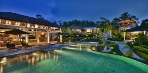 an image of a villa with a swimming pool at night at Alta Vista Mountain Villa Bali in Gitgit