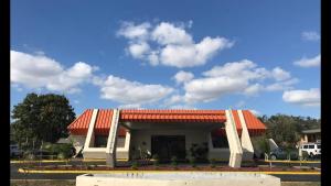 a building with an orange roof in a parking lot at Enterprise Motel in Kissimmee