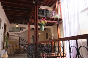 un pasillo con un jarrón de flores en el balcón en Hotel Colonial San Agustin, en Quito