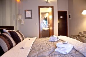 1 dormitorio con 1 cama con toallas en Grimani Pension, en Nauplia