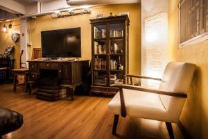 a living room with a television and a chair at Thai Thai Hostel in Chiang Mai