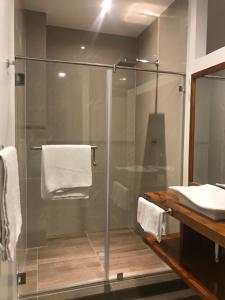 a glass shower in a bathroom with a sink at Hotel La Isla in Puerto Ayora