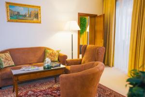 a living room with a couch and two chairs at Royal Plaza in Nefteyugansk