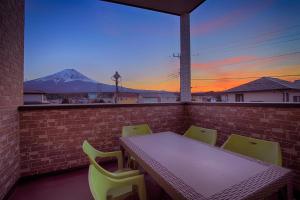 d'une table et de chaises sur un balcon avec vue sur la montagne. dans l'établissement Villas Fuji, à Fujikawaguchiko