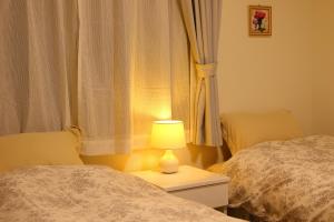 - une chambre avec deux lits et une lampe sur une table dans l'établissement Villas Fuji, à Fujikawaguchiko