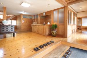 a large room with wooden walls and a wooden floor at Minshuku Asogen in Aso