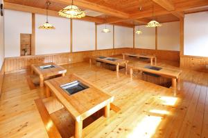 an empty room with wooden tables and benches at Minshuku Asogen in Aso