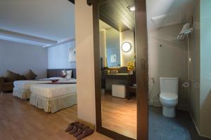 a bedroom with a bed and a bathroom with a toilet at Kiss Gardenhome Chic Hotel in Hat Yai +80 photos