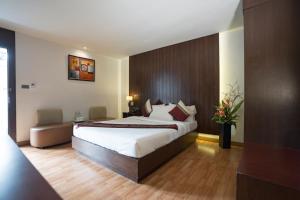 a bedroom with a large bed in a room at Kiss Gardenhome Chic Hotel in Hat Yai