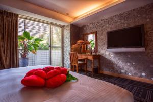 台北的住宿－采舍精品旅館，卧室配有一张床上的红色大枕头