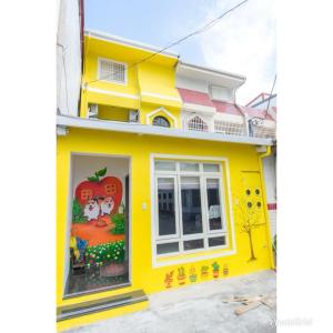 uma casa amarela com uma pintura ao lado dela em Apple House em Hualien City