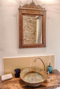 a bathroom with a stone sink and a mirror at Dominic Boutique - Gardener's Cottage in Cloaşterf