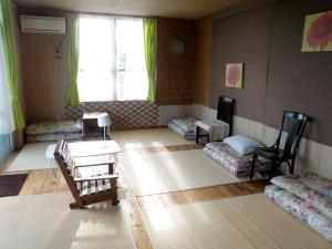 名護市にある沖縄素泊まり宿やんばるふくろうのリビングルーム(椅子、テーブル付)、窓が備わります。