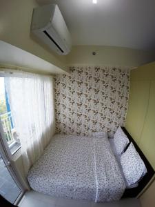 a small bedroom with a bed and a window at Wind Residence Condo - Tagaytay by jaderooms in Tagaytay +25 photos