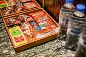 ein Tablett mit Essen auf einem Tisch mit zwei Flaschen Wasser in der Unterkunft Cai She Hotel in Taipeh